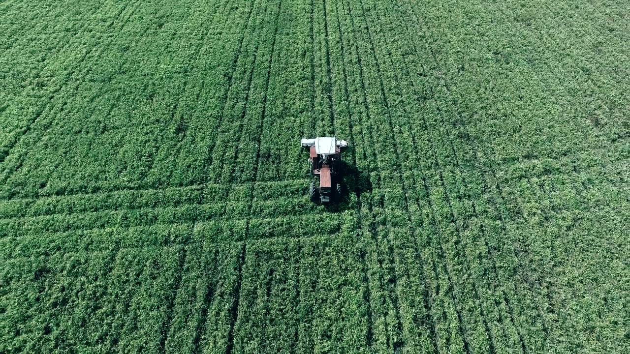 A tractor working a field, shot from above.